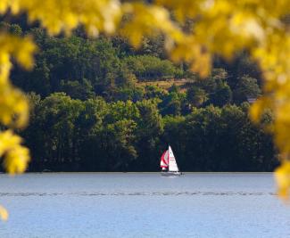 Voilier sur le plan d'eau Le voilier est en train de naviguer sur le plan d'eau de la base de loisirs du Tarn-et-Garonne