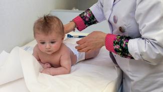 Image représentant la petite enfance  Un médecin examine un bébé