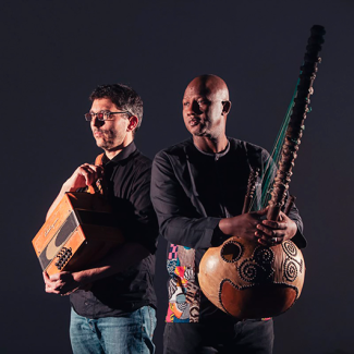 Concert de Ablaye Cissoko & Cyrille Brotto à l'espace des Augustins Deux hommes qui regardent à gauche avec chacun un instrument dans les mains